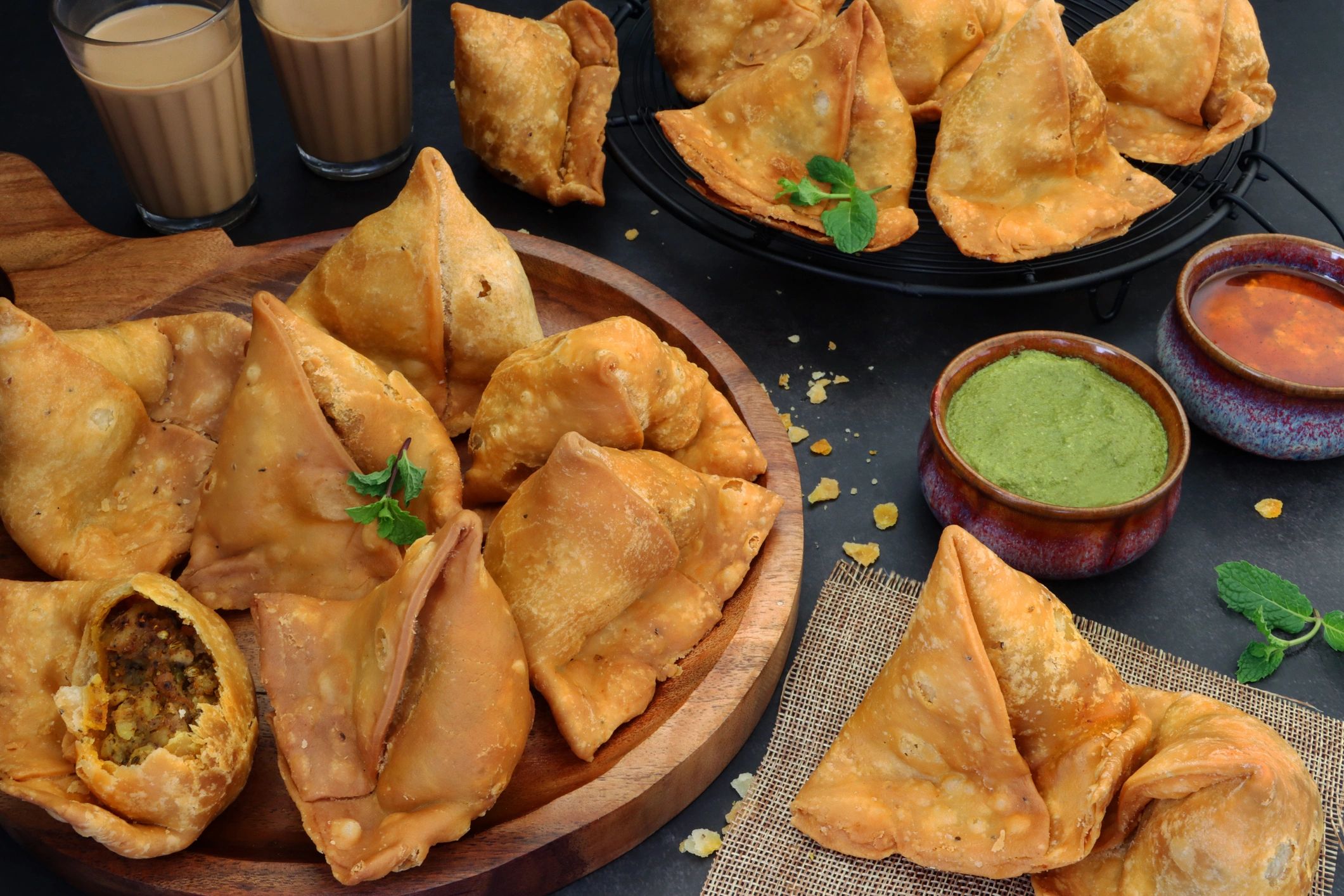 Samosas with chutneys on a board