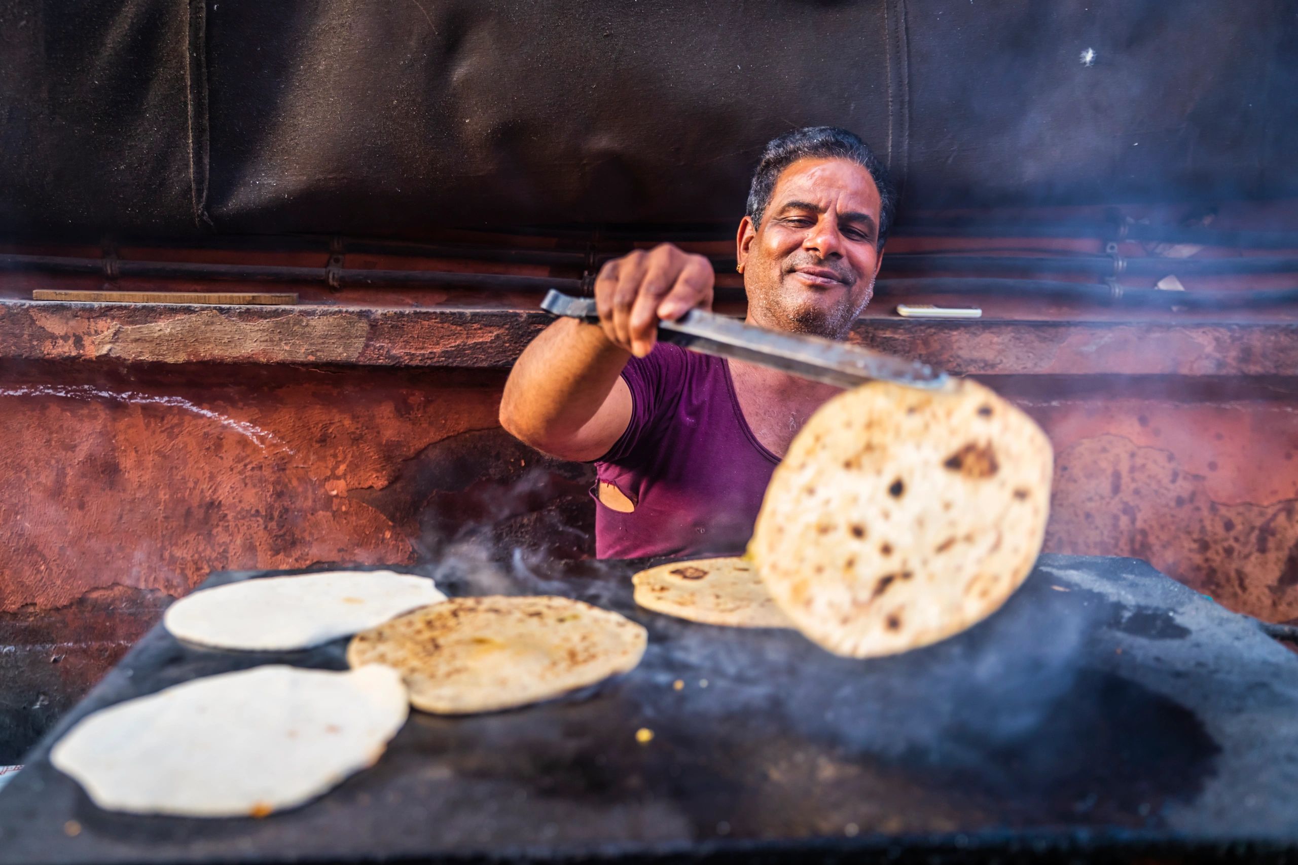Chef preparing fresh flatbread on a hot griddle
